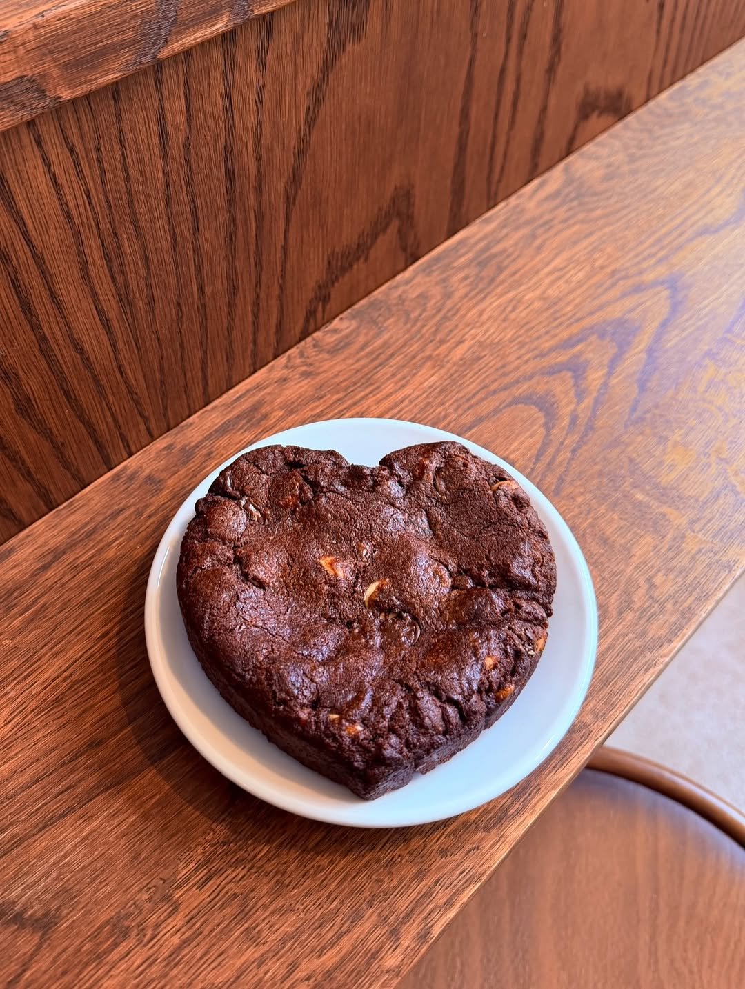 Homemade heart-shaped chocolate cookie on a white plate